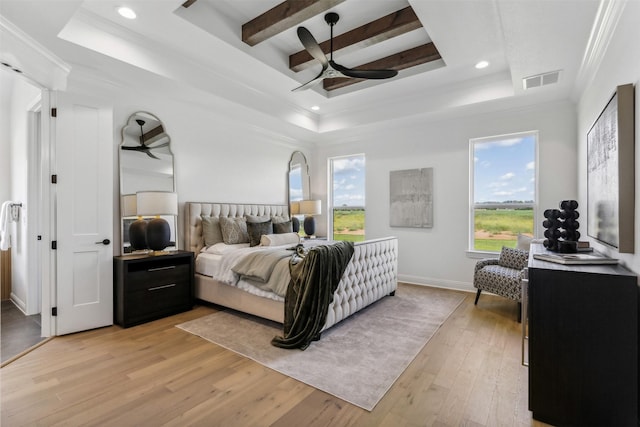 bedroom featuring ceiling fan, light wood-type flooring, ornamental molding, and a tray ceiling