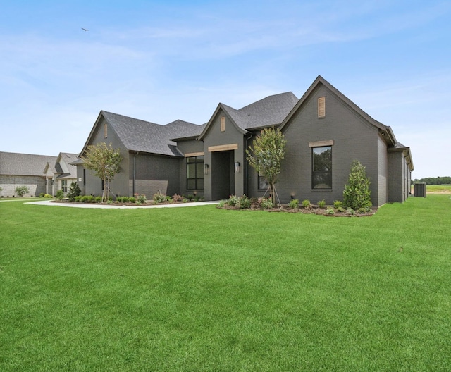 view of front of house featuring a front yard and central AC