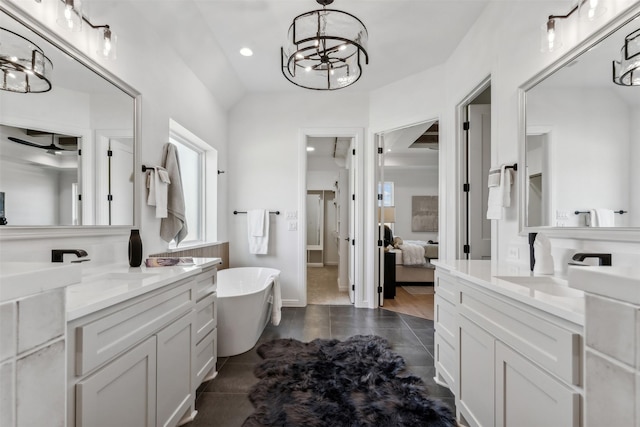 bathroom featuring a bathing tub, a notable chandelier, wood-type flooring, and vanity