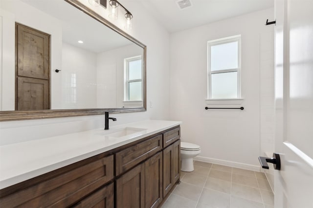 bathroom featuring toilet, tile patterned flooring, walk in shower, and vanity