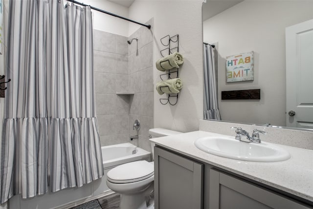 full bathroom featuring vanity, shower / bath combo with shower curtain, and toilet