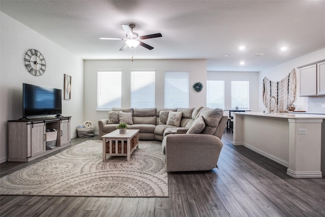 living room featuring a healthy amount of sunlight, ceiling fan, and dark hardwood / wood-style flooring