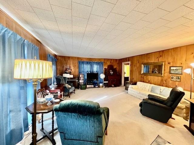 carpeted living room featuring wooden walls