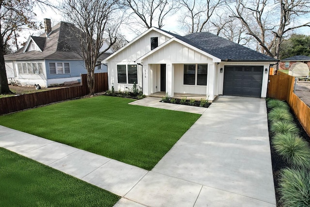 view of front of home featuring fence, driveway, a front lawn, a garage, and board and batten siding