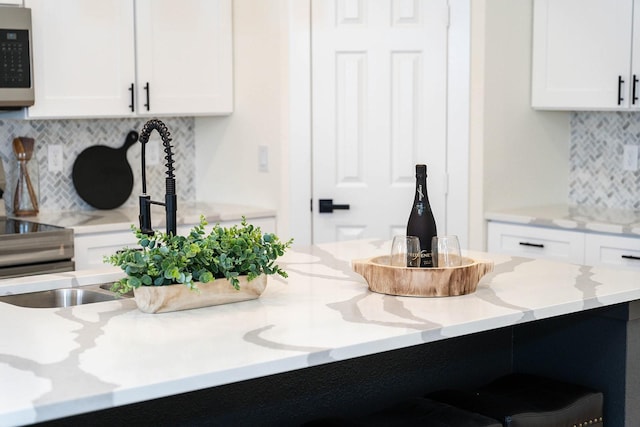 room details with light stone countertops and white cabinets