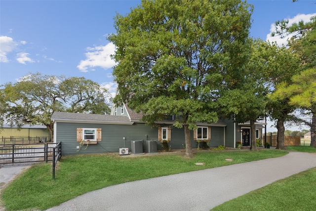 ranch-style home featuring a front lawn and central AC unit