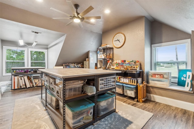 kitchen featuring lofted ceiling, a textured ceiling, ceiling fan, and light hardwood / wood-style floors