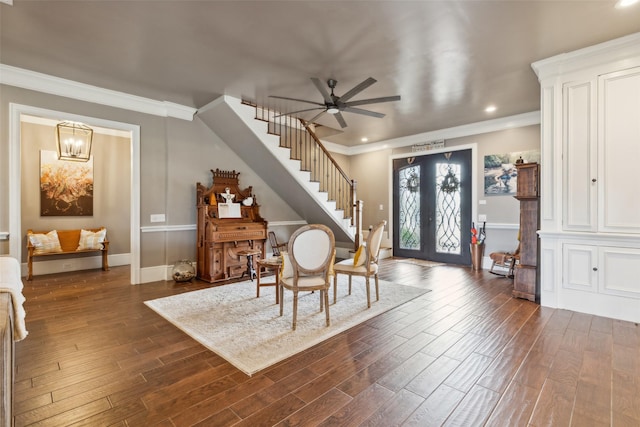 foyer entrance featuring ceiling fan with notable chandelier, french doors, and ornamental molding