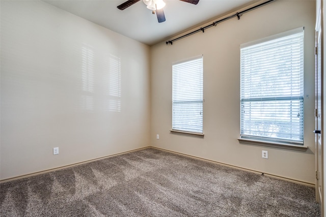 empty room with plenty of natural light, ceiling fan, and carpet