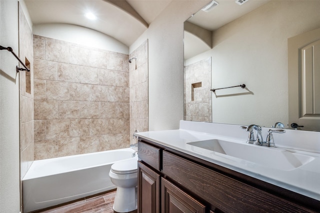 full bathroom with toilet, tiled shower / bath, and vanity