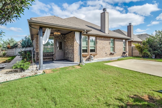 back of house with a patio, ceiling fan, and a lawn