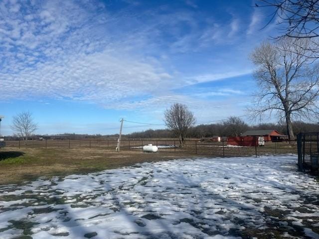 yard covered in snow featuring a rural view