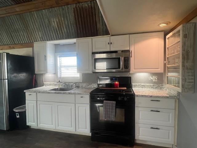 kitchen featuring appliances with stainless steel finishes, white cabinetry, light stone countertops, and sink