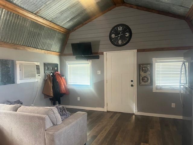 living room featuring dark wood-type flooring, high vaulted ceiling, and a wall unit AC