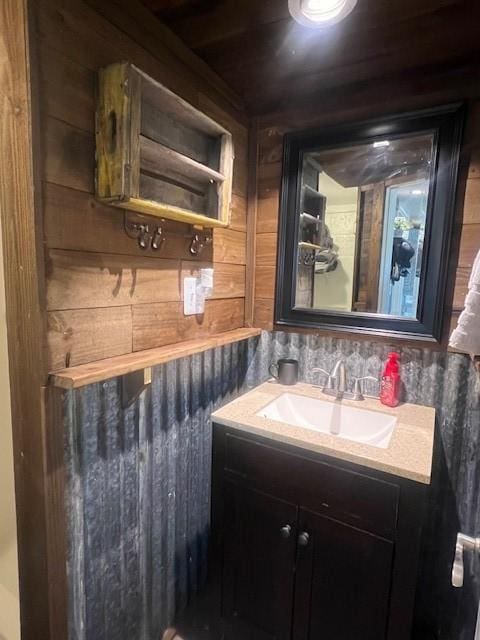 bathroom with vanity and wood walls