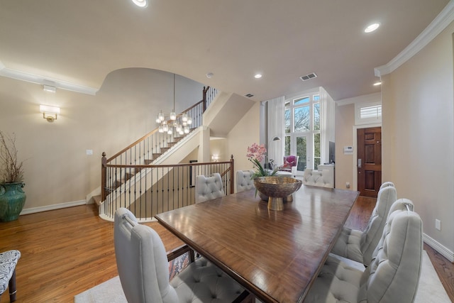 dining room featuring light hardwood / wood-style flooring, crown molding, and a notable chandelier