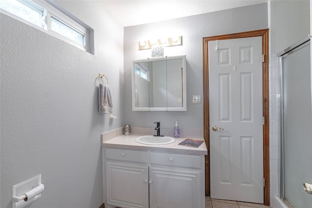 bathroom featuring vanity, an enclosed shower, and tile patterned flooring