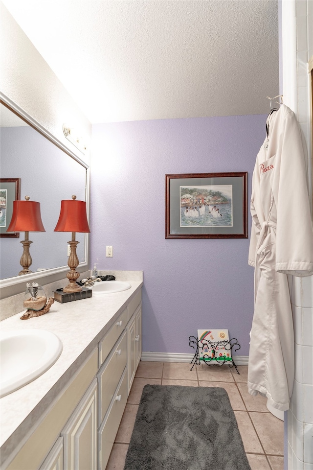 bathroom with a textured ceiling, tile patterned floors, and vanity