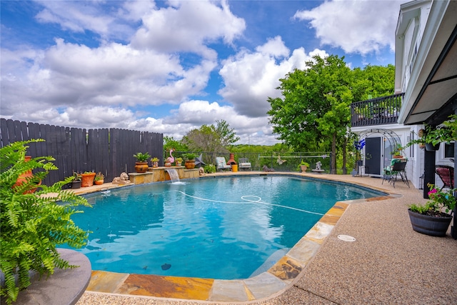 view of swimming pool with pool water feature and a patio