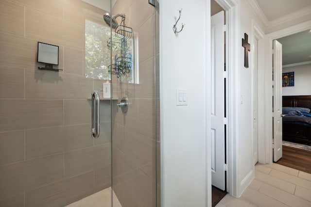 bathroom featuring ornamental molding, tiled shower, and tile patterned floors