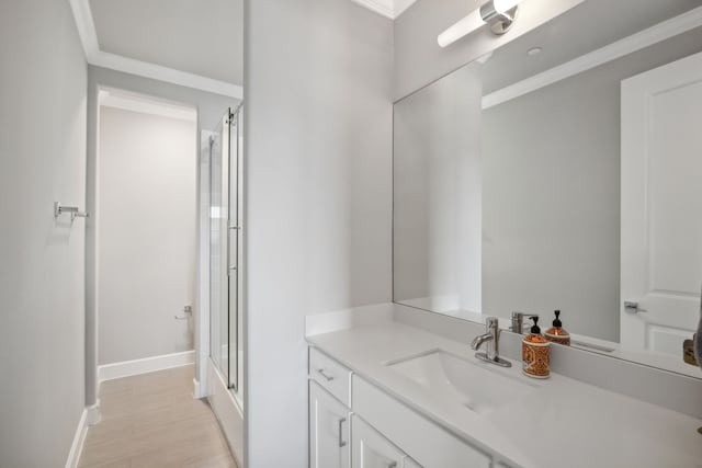 bathroom with a shower with door, ornamental molding, and vanity