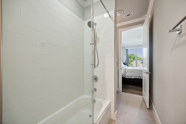 bathroom featuring ornamental molding and tiled shower / bath