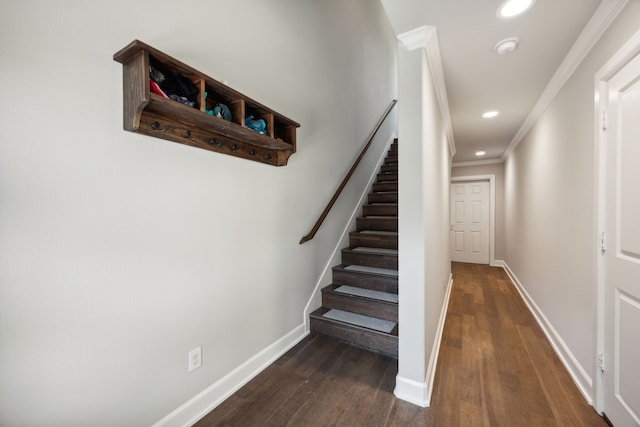 staircase with wood-type flooring and crown molding