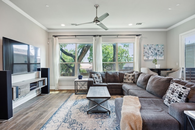 living room featuring ceiling fan, crown molding, a wealth of natural light, and hardwood / wood-style flooring