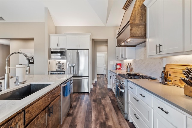 kitchen with premium range hood, high end appliances, dark hardwood / wood-style floors, white cabinetry, and sink