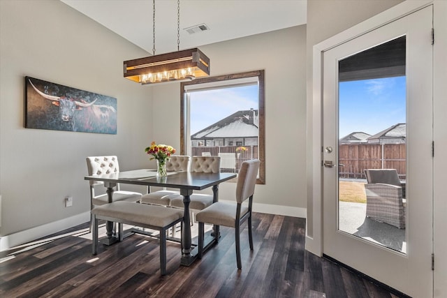 dining room with vaulted ceiling, a notable chandelier, and dark hardwood / wood-style floors