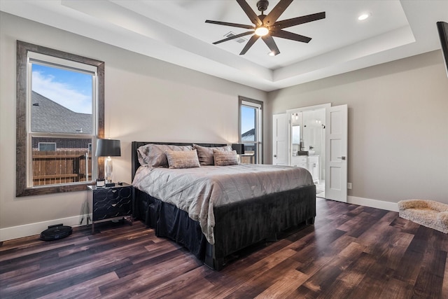 bedroom featuring ceiling fan, a tray ceiling, and dark hardwood / wood-style floors