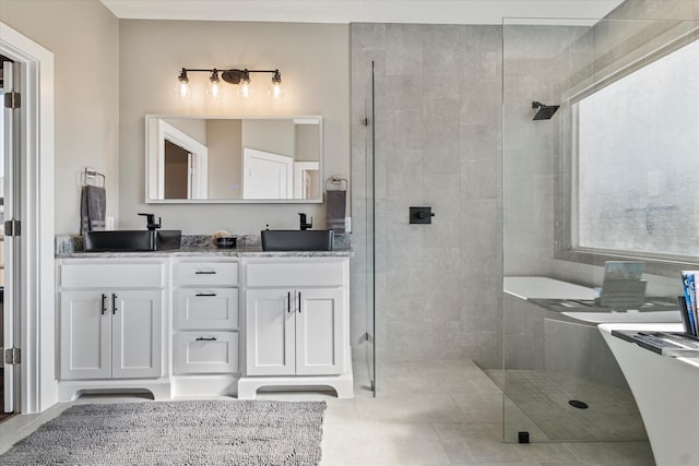 bathroom with tiled shower and vanity