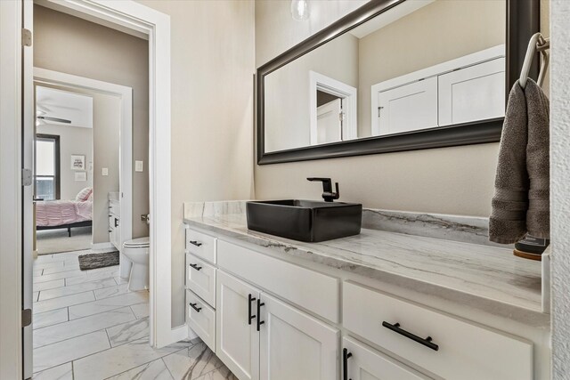 bathroom with ceiling fan, vanity, and toilet