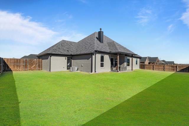 rear view of house with central air condition unit and a lawn