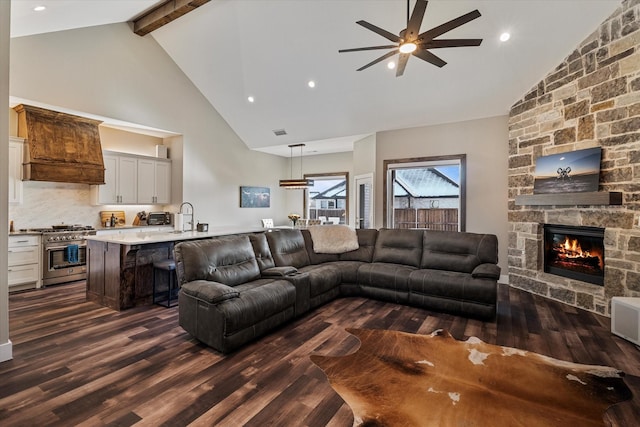 living room featuring high vaulted ceiling, dark hardwood / wood-style flooring, a fireplace, and beamed ceiling