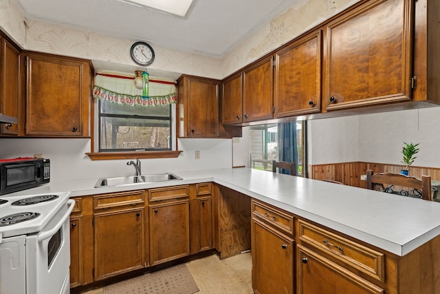 kitchen with sink, kitchen peninsula, wood walls, and white range with electric stovetop