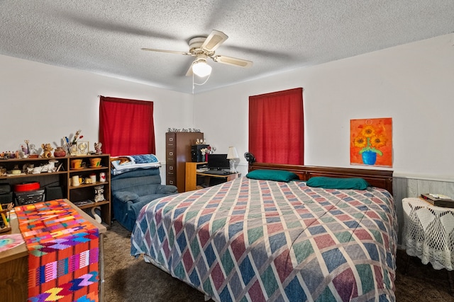 carpeted bedroom with ceiling fan and a textured ceiling