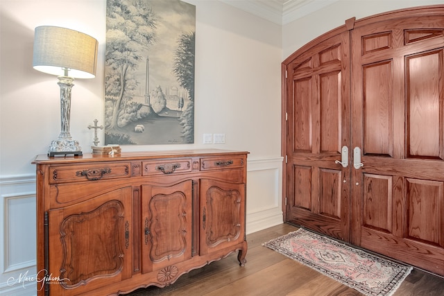 foyer with hardwood / wood-style flooring and crown molding