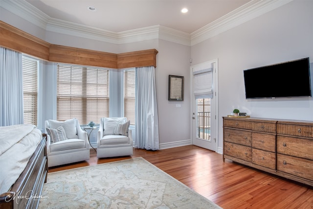 sitting room with ornamental molding and light hardwood / wood-style flooring