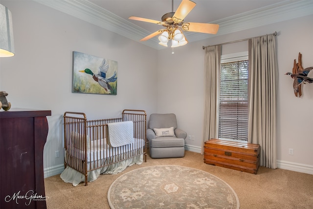 bedroom with ceiling fan, light colored carpet, crown molding, and a crib