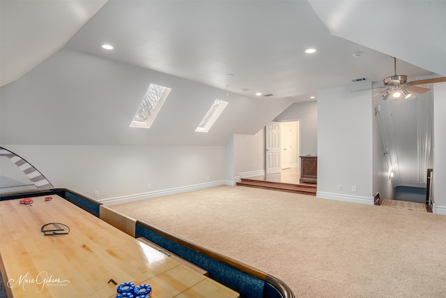 interior space featuring ceiling fan and vaulted ceiling with skylight