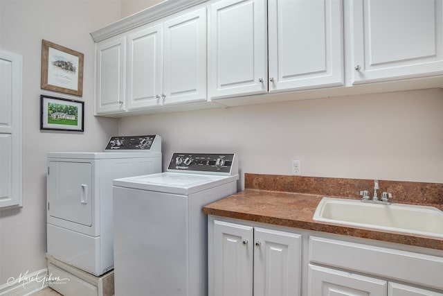 laundry area featuring cabinets, separate washer and dryer, and sink