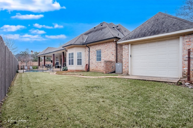 back of house with a garage, a patio area, and a yard