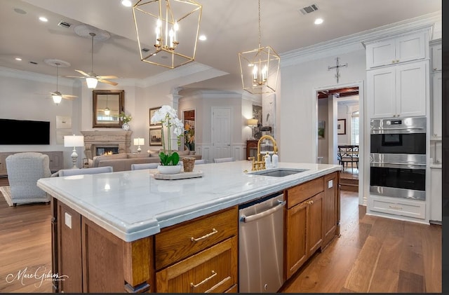 kitchen featuring ceiling fan, sink, white cabinetry, appliances with stainless steel finishes, and an island with sink