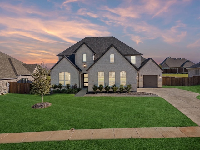 french country inspired facade with a lawn and a garage