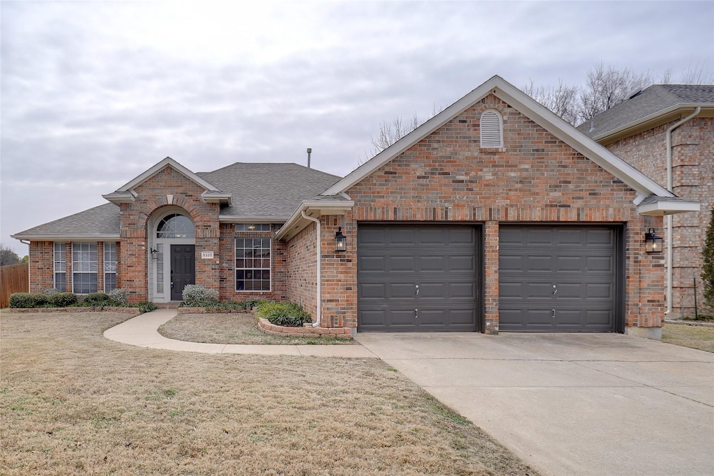 view of front of property with a front yard and a garage