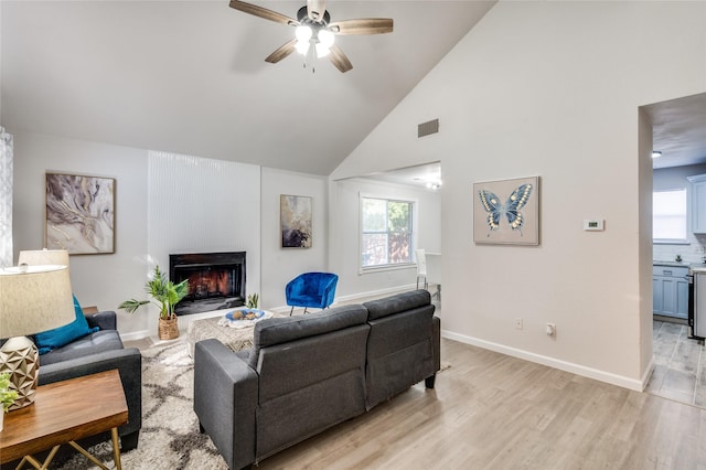 living room with high vaulted ceiling, light wood-type flooring, and ceiling fan