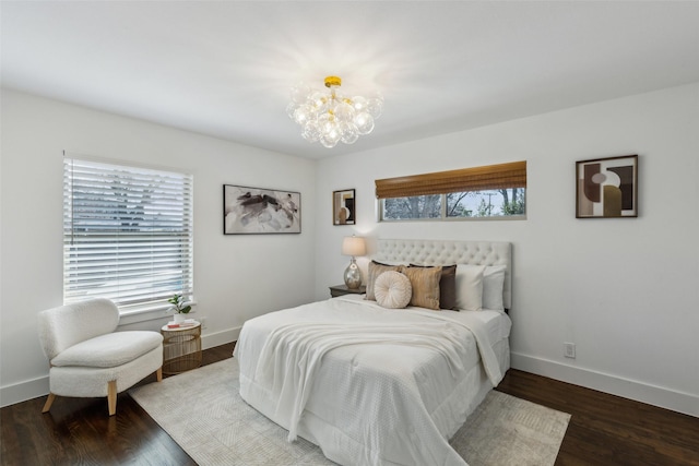 bedroom featuring a chandelier, dark hardwood / wood-style flooring, and multiple windows