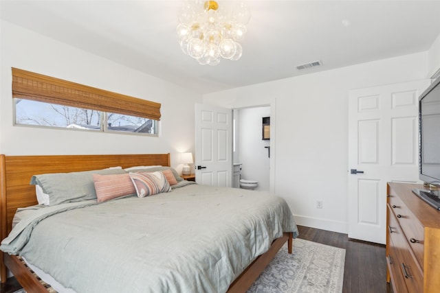 bedroom featuring connected bathroom, dark hardwood / wood-style flooring, and an inviting chandelier