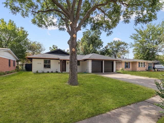 single story home featuring a front lawn and a garage